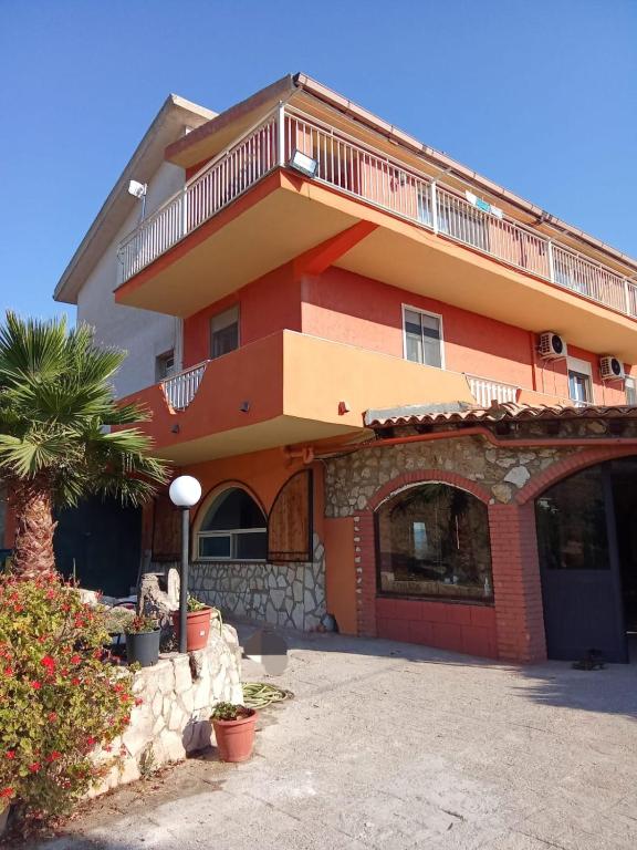a large orange building with a balcony on top at Casa Presenza in Santa Elisabetta