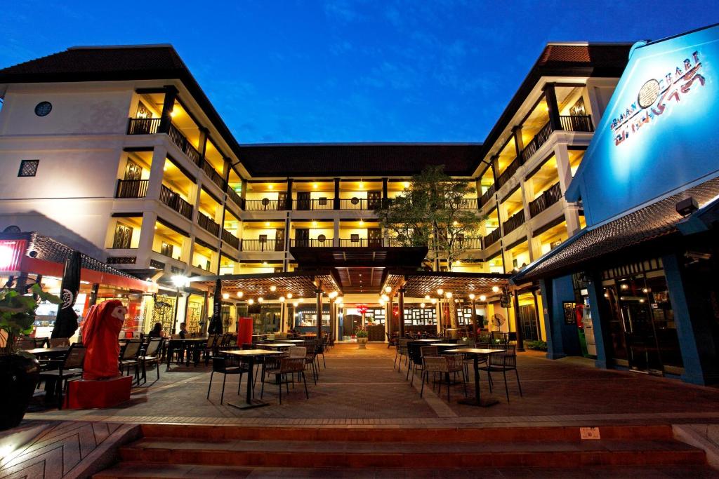 a building with tables and chairs at night at Baan Chart in Bangkok