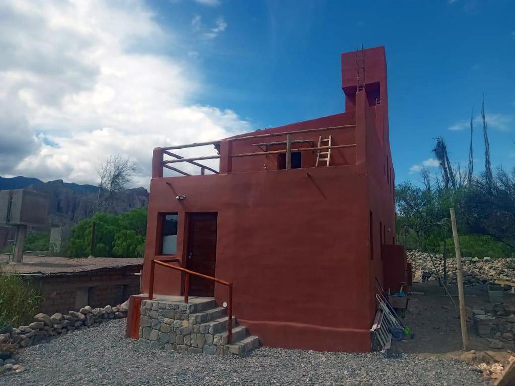 a red building with a staircase in front of it at Alojamiento La Oti in Tilcara