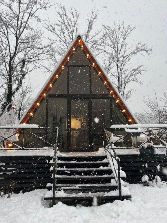 een klein gebouw met verlichting in de sneeuw bij Cottage Tetra Kutaisi Tskaltubo in Khomuli