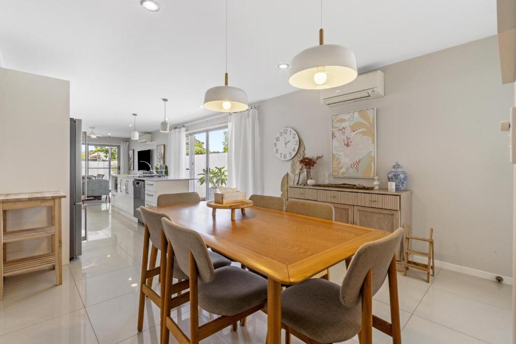 a kitchen and dining room with a wooden table and chairs at Spacious 4-Bed House with Secure Parking in Brisbane