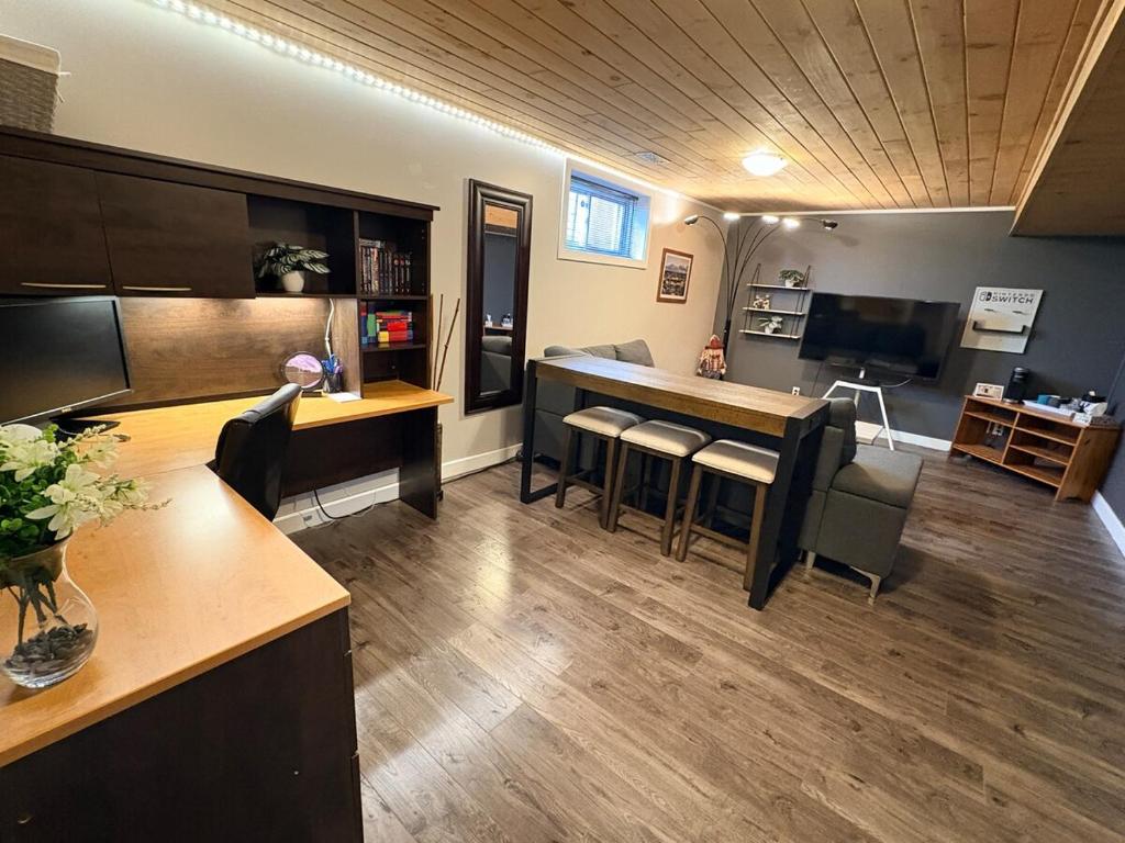 een woonkamer met een bar en een aantal stoelen bij Private spacious oversized suite with free parking in Kingston