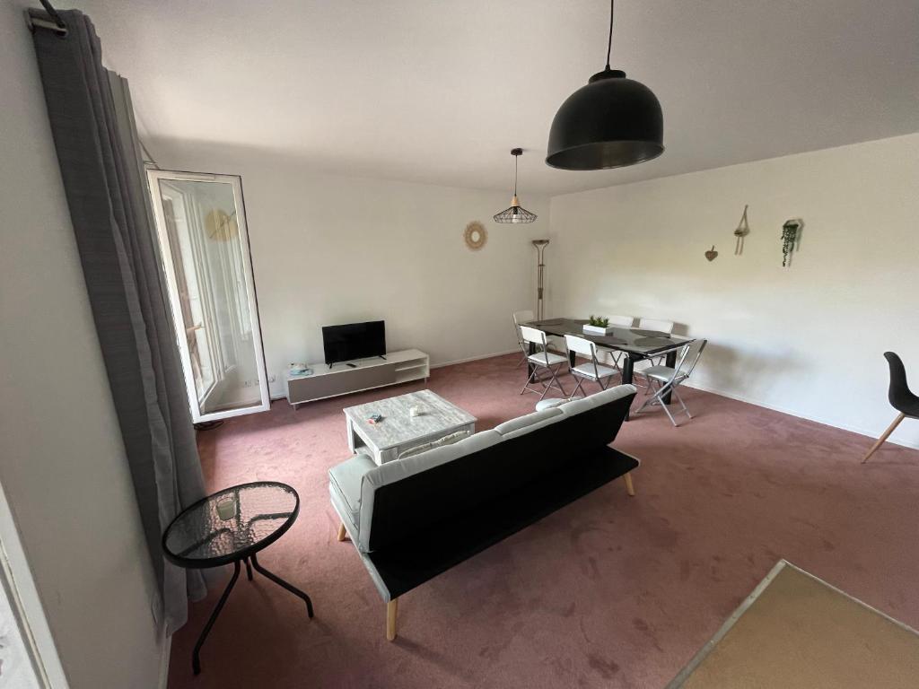 a living room with a couch and a table at Appartement Saint Genis Pouilly Cern in Saint-Genis-Pouilly