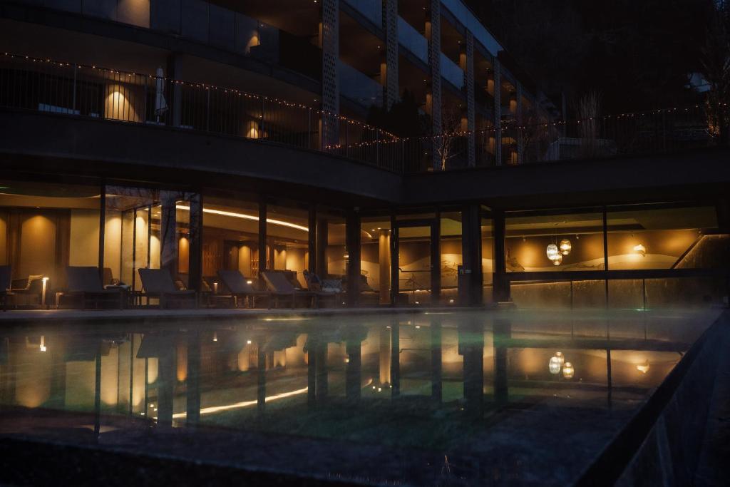 un edificio con piscina di notte di Hotel Bad Fallenbach a San Leonardo in Passiria