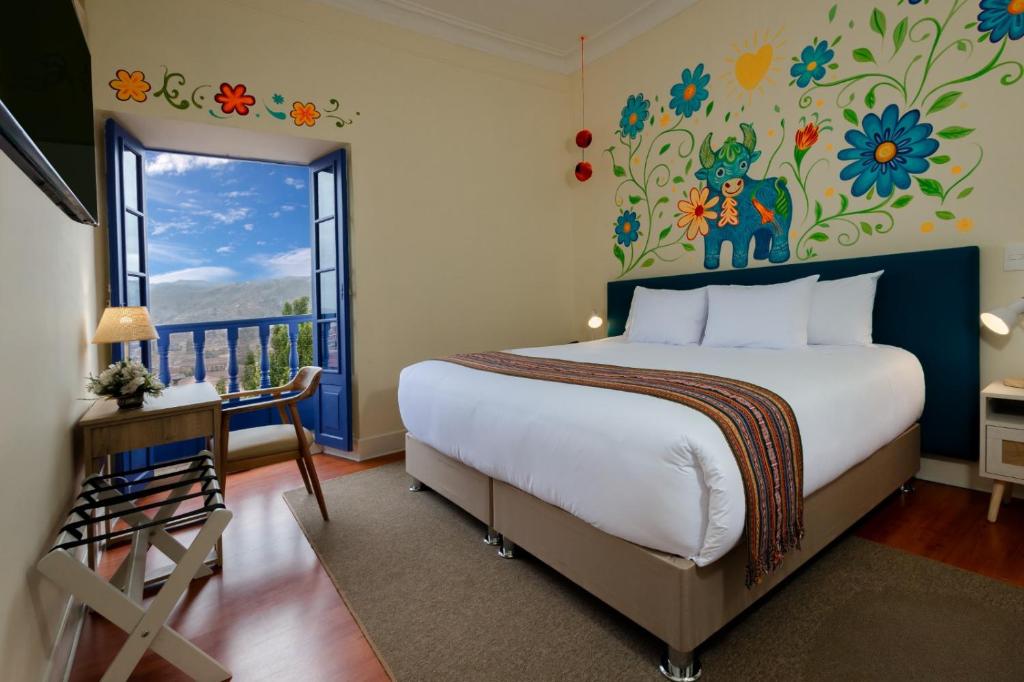 a bedroom with a large bed with a flowery wall at 7 Toritos Hotel Boutique by Hacienda in Cusco