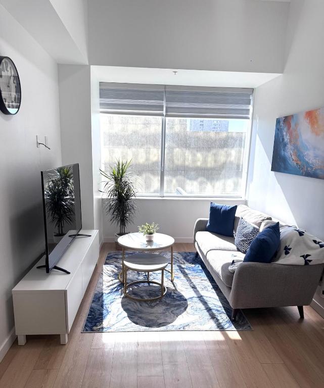 un soggiorno con un divano e un tavolo di Cozy 1-Bedroom with Natural lights a Edmonton