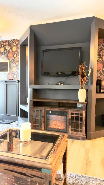 a living room with a fireplace and a tv at Cozy boho downtown apartment in Calgary