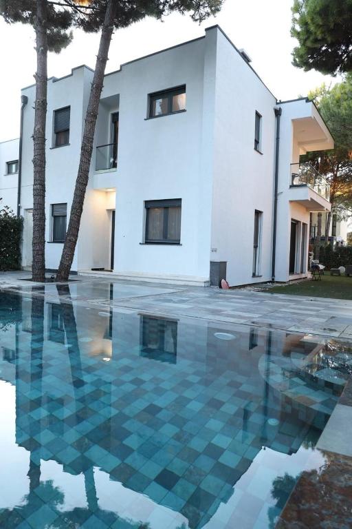 a villa with a swimming pool in front of a house at Peonia Villa ValaMar in Draç