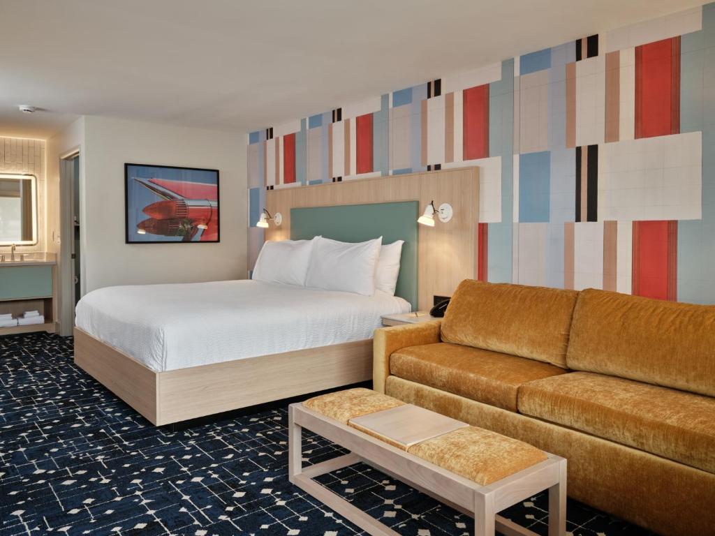 een hotelkamer met een bed en een bank bij Colony House Motor Lodge in Roanoke