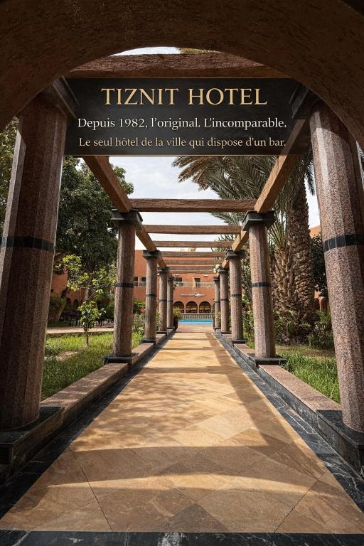 a walkway leading to a train hotel with a sign at Tiznit Hotel in Tiznit