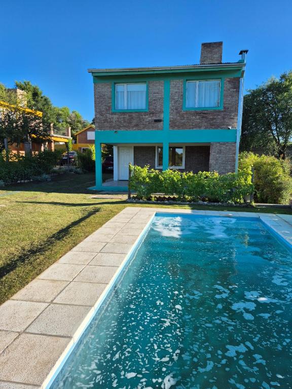 une maison avec une piscine devant une maison dans l'établissement Cabaña La Zarzamora, à La Estancia