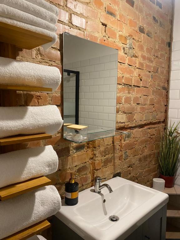 een badkamer met een wastafel, een spiegel en handdoeken bij SecondHomeViljandi Apartment in Viljandi