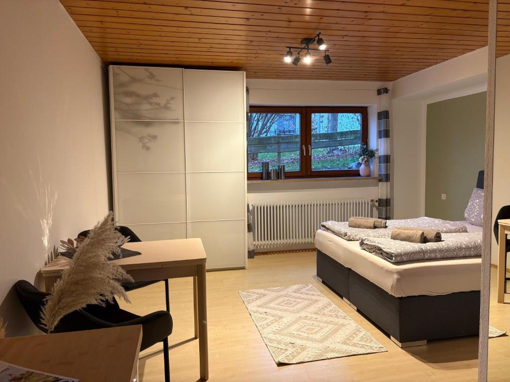 una camera da letto con un letto, una scrivania e una finestra di Ruhig gelegenes Ferienzimmer in Bodolz a Lindau-Bodolz