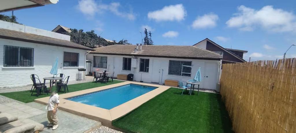 een achtertuin met een zwembad en een huis bij Hostal Escondido in La Serena