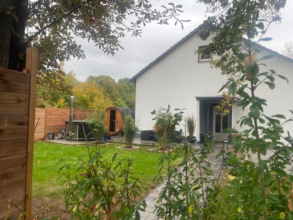 a white house with a garden in front of it at Ferienhaus am Seeburgersee 100 Meter zum Wasser in Niederdorla