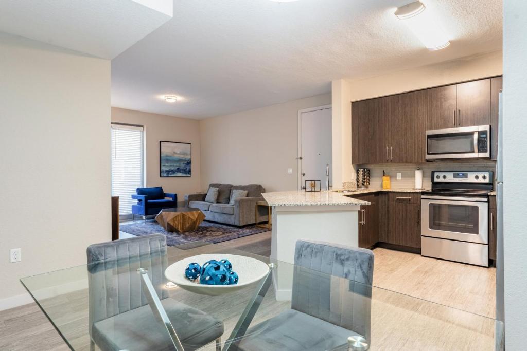 a kitchen and living room with a table and chairs at Spacious 3BR | Pool, Gym, Near Beach & Speedway in Daytona Beach