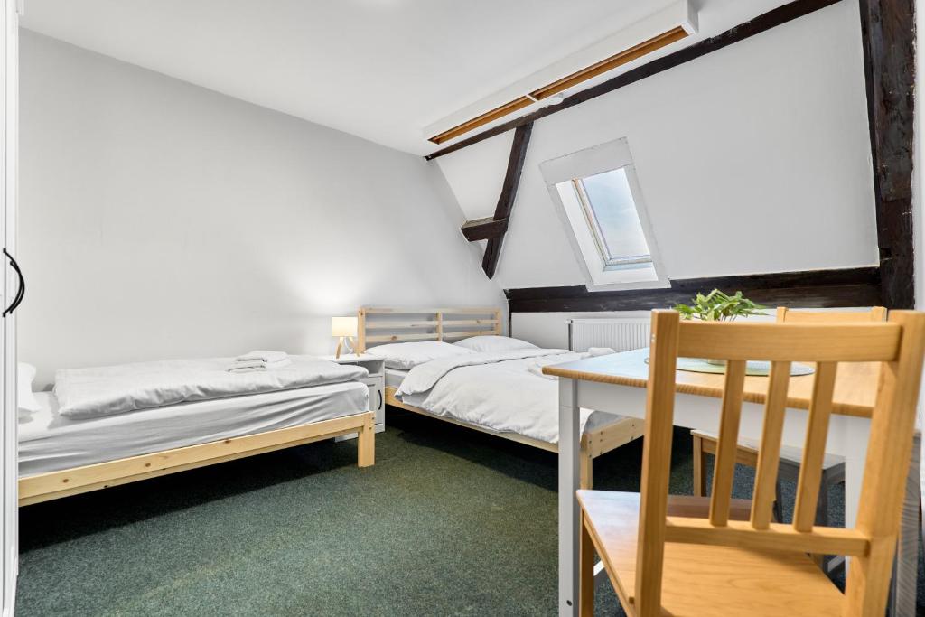 two beds in a room with a table and a chair at Horská chata Silver by Mountain ways in Boží Dar