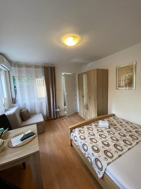 una camera da letto con un letto grande e un soggiorno di Apartman Mia 1 Igalo Centar a Igalo