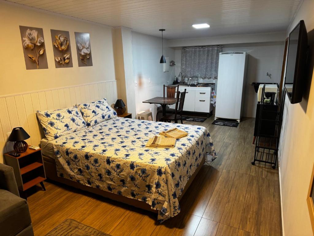 una piccola camera da letto con un letto e una cucina di Vivaê Studio a Vila Velha