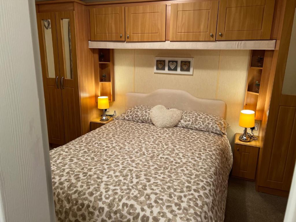 a bedroom with a large bed with two lamps at A and C Coastal Hideaway Private Decking in Colchester