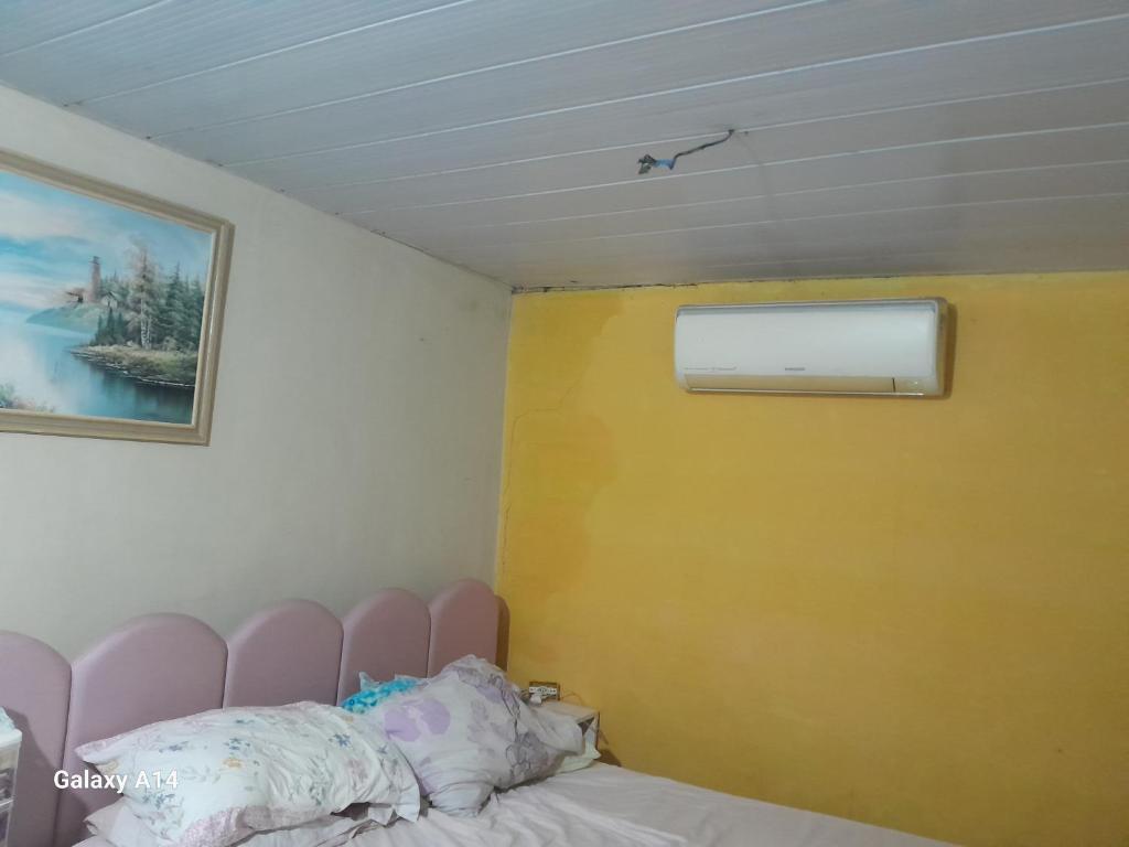 a bedroom with a pink headboard and a yellow wall at Casa para alugar para o Carnaval in Recife