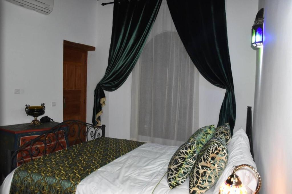 a bedroom with a bed with a canopy at Chambres Émeraude et Rubis - Riad Lotus Bleu in Fès