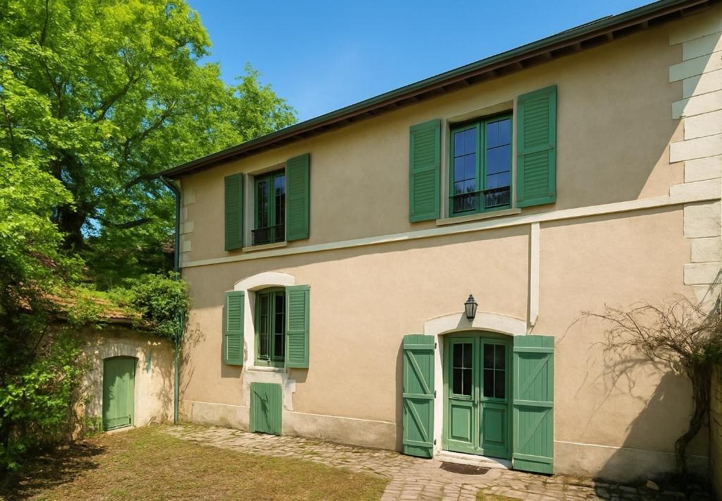 een huis met groene luiken erop bij Echappée verte et jacuzzi proche de Paris in Vert-le-Grand