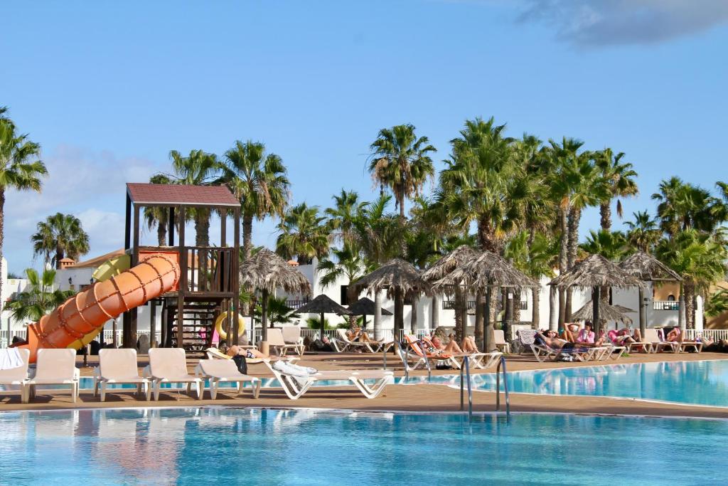 a pool at a resort with a water slide at Casa Nube in Corralejo