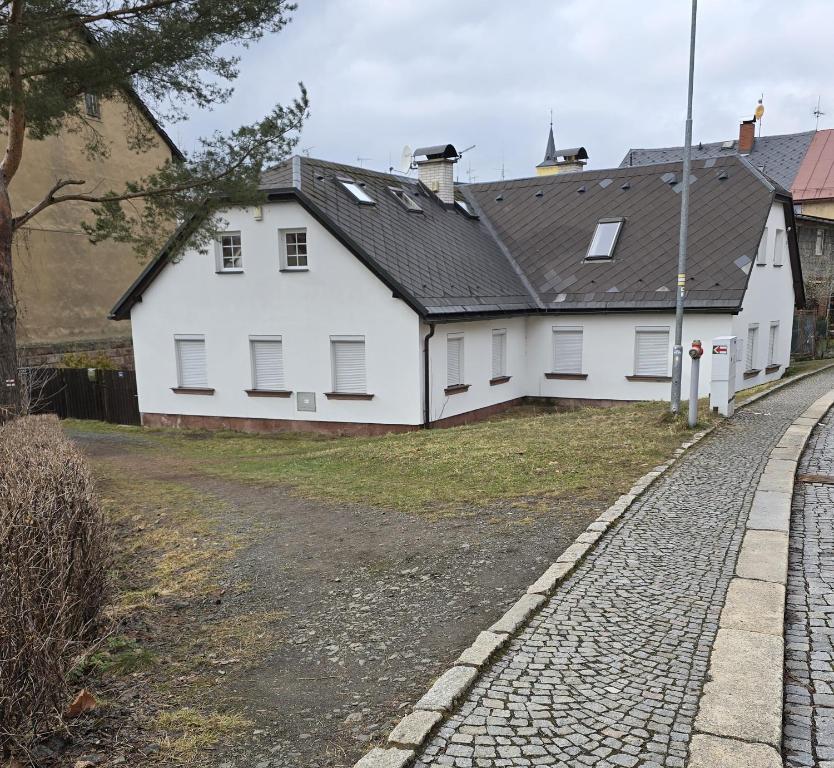 a white house on the side of a road at Popelucha in Lomnice nad Popelkou