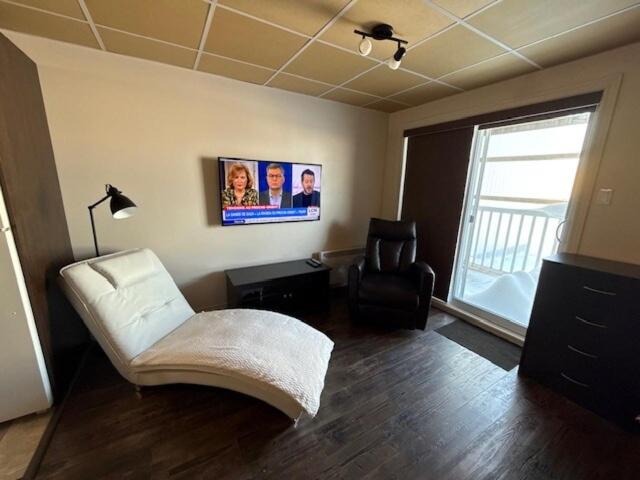 a living room with a couch and a chair at Studio #1 avec balcon tout inclus in Baie-Comeau