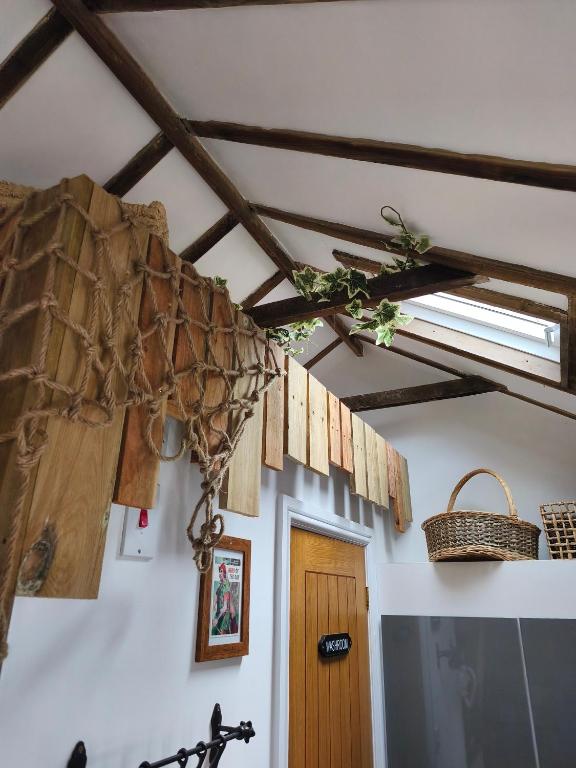 a room with a ceiling with wooden beams and a door at Zanders cave in Edwinstowe
