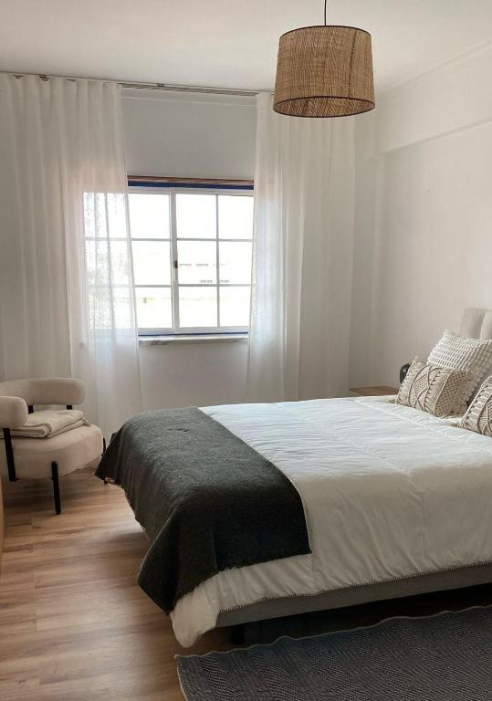 a bedroom with a large bed and a window at Apartamento - The Light House in Peniche