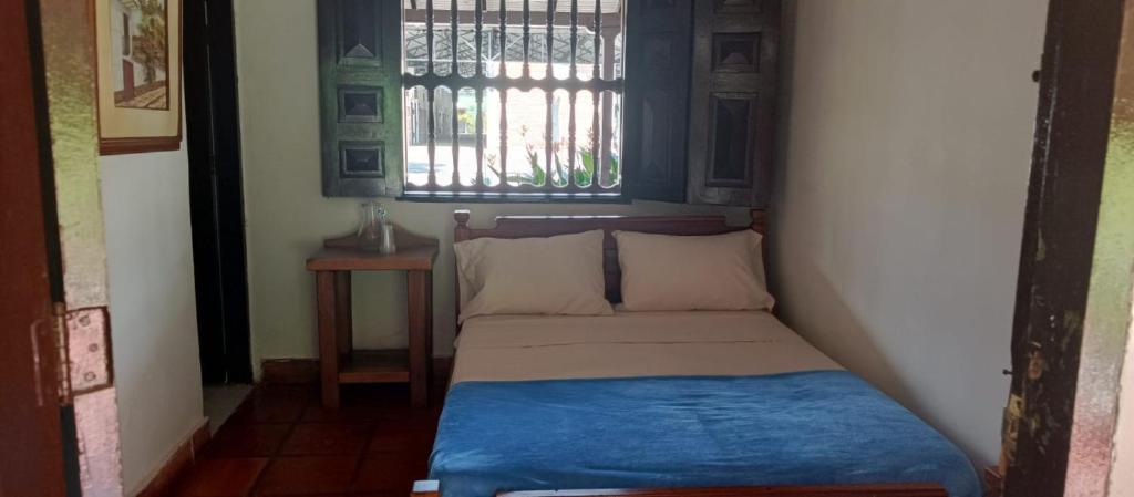 een klein bed in een kamer met een raam bij Finca Hotel El Juncal in Venecia