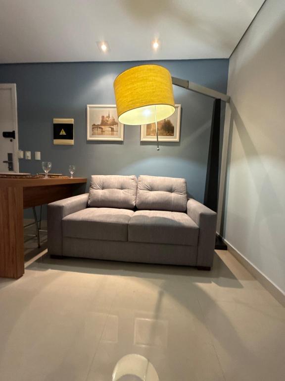 a living room with a couch and a yellow lamp at Flat completo e confortável in Cuiabá