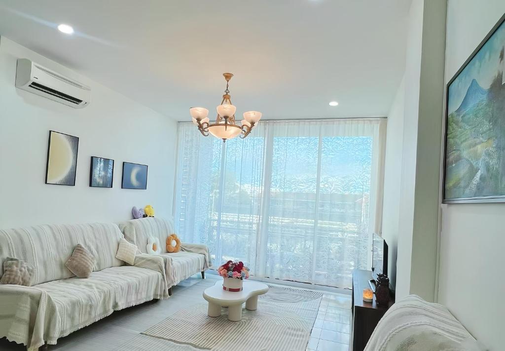 ein Wohnzimmer mit einem weißen Sofa und einem Kronleuchter in der Unterkunft 涵舍homestay in Sibu
