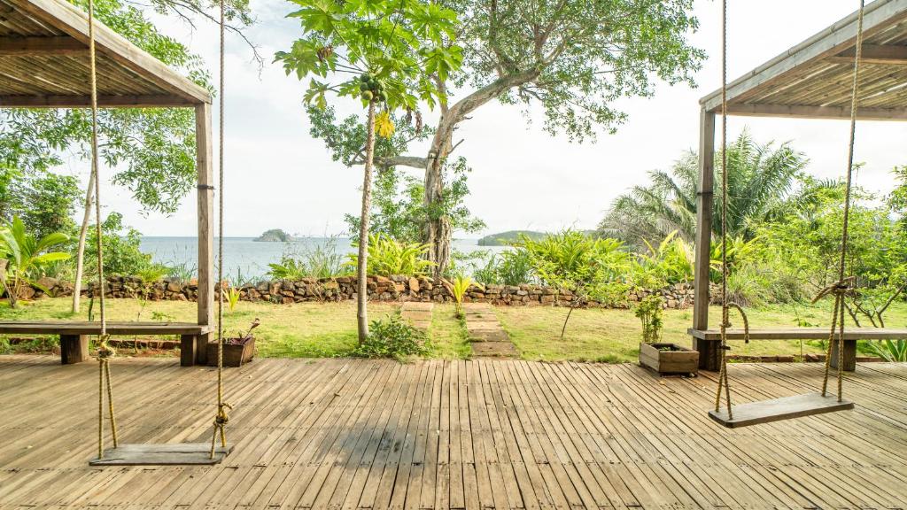 a porch with swings and a view of the ocean at Casa do Mar in São Tomé