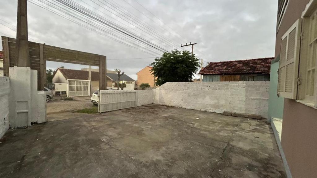 un parcheggio vuoto di fronte a un muro di mattoni di Microcasa Nascimento a Imbituba