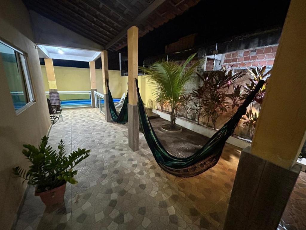 Ein Zimmer mit zwei Hängematten in einem Gebäude mit Pflanzen in der Unterkunft casa em peroba in Maragogi