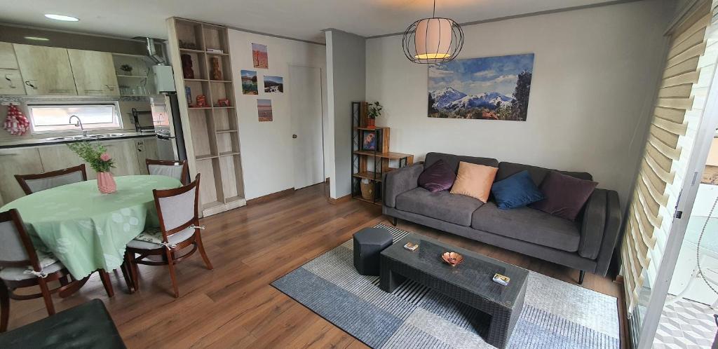 een woonkamer met een bank en een tafel bij Detached house on the second floor in Santiago