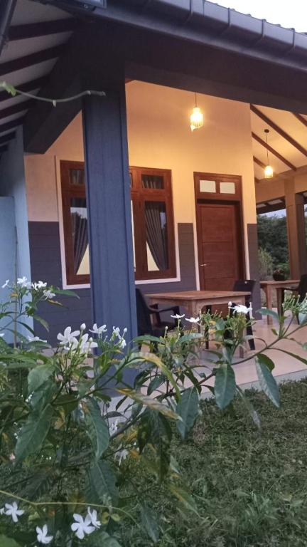 a house with a porch with flowers in front of it at Wild Night Hostel Sigiriya in Sigiriya