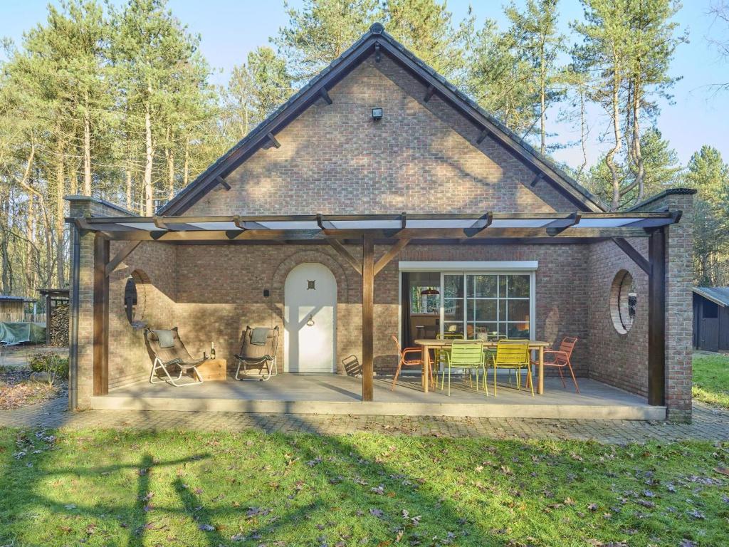 a barn style house with a patio and a table at Lierelodge in Oud-Turnhout