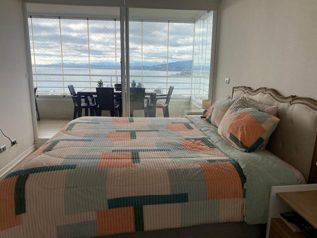 a bedroom with a bed with a view of the ocean at Dpto 2 dormitorios vista al mar in Concón