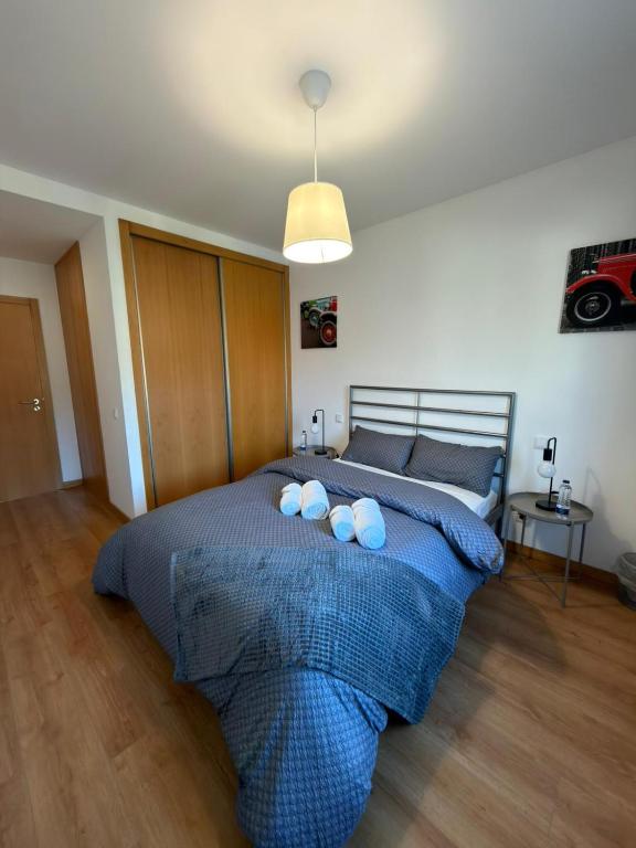 a bedroom with a bed with a blue comforter at Alojamento Local Pando in Vila do Conde