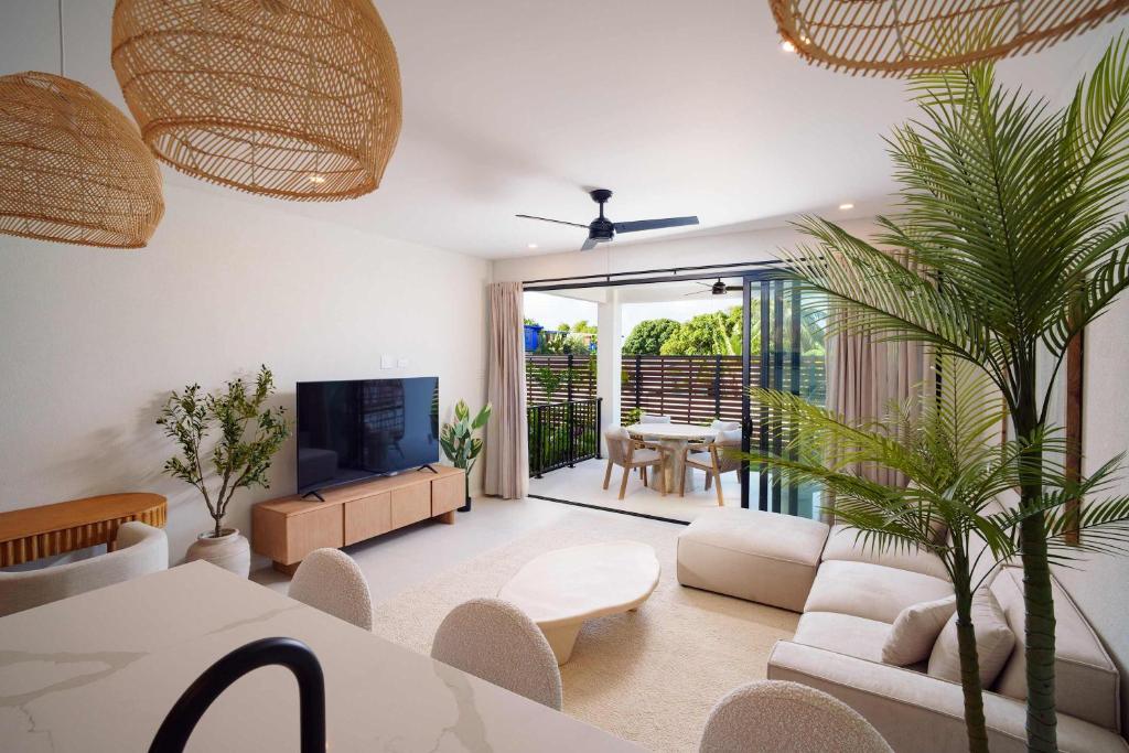 a living room with a couch and a table and a tv at Elegant LUX 2BR 3mins to Beach Pool & Deck in Saint James