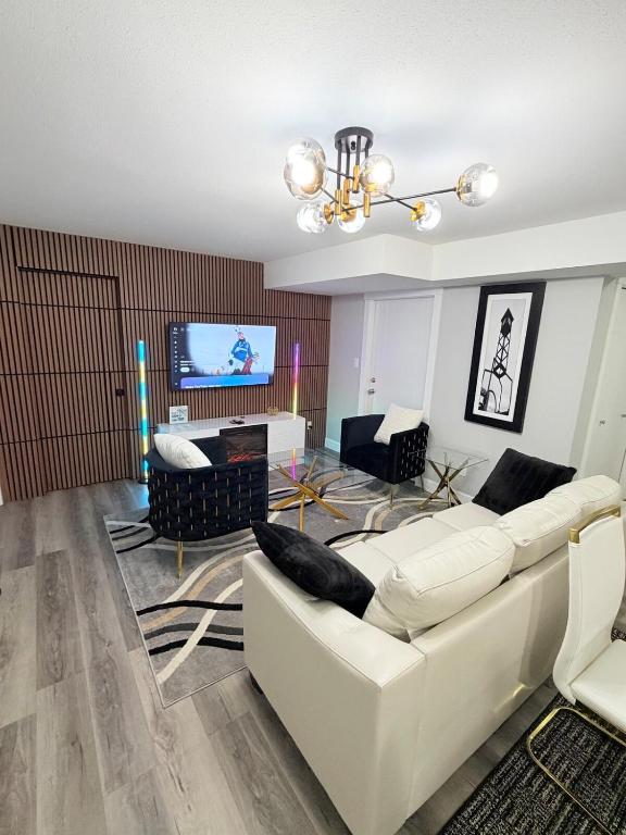 een woonkamer met een witte bank en een tv bij True Haven Deluxe in Prince George