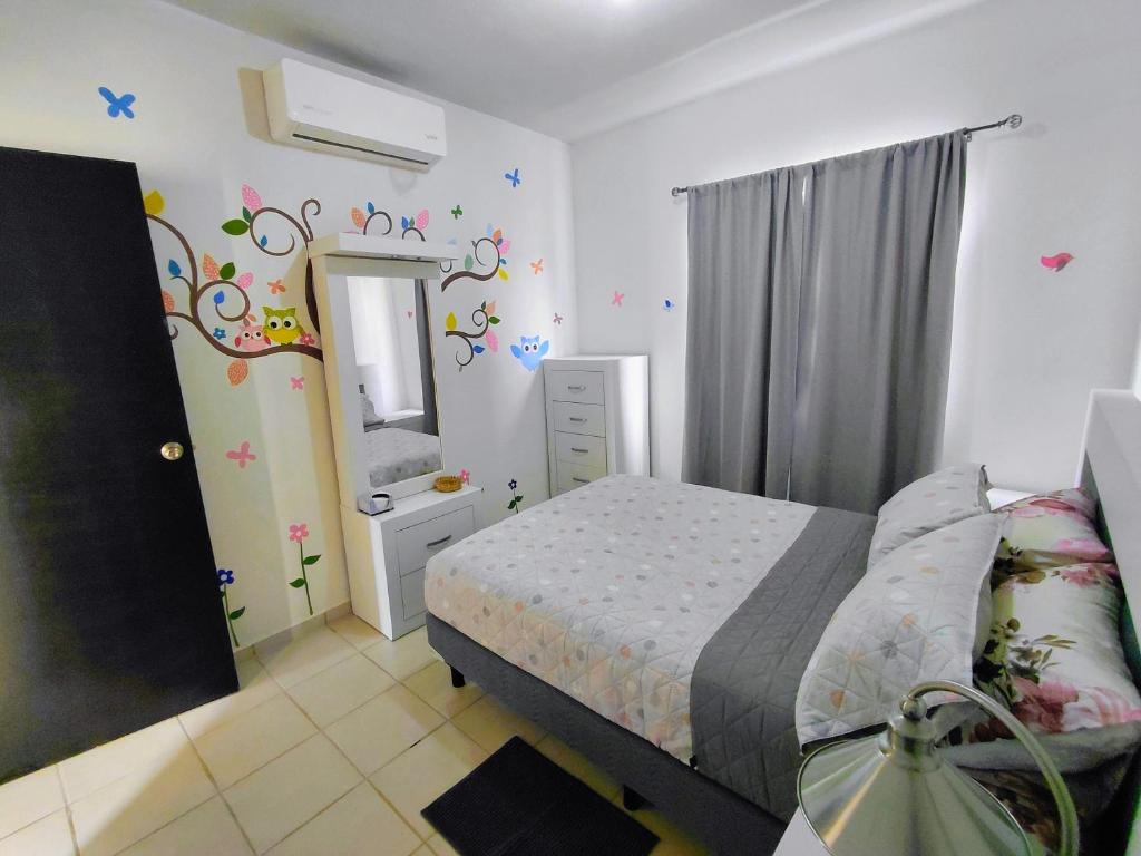 a small bedroom with a bed and a mirror at Casa privada Mediterráneo in La Paz