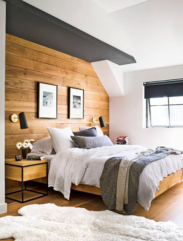 a bedroom with a large bed with a wooden wall at RNG apartment in Abbeyville
