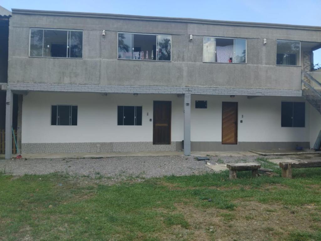 een gebouw met deuren en een bankje ervoor bij Hospedagem estação in Morretes