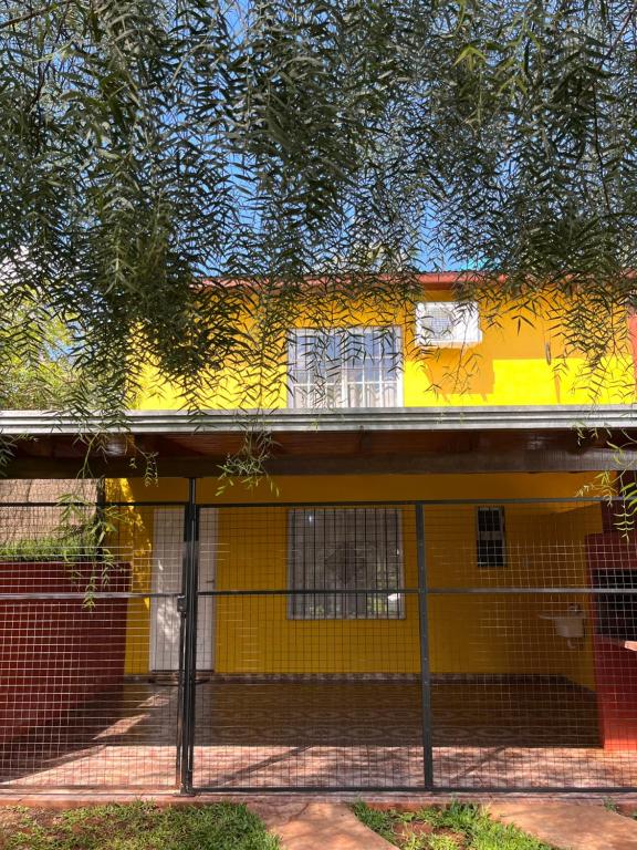 a yellow house with a fence in front of it at Eucalipto Dúplex in San Vicente