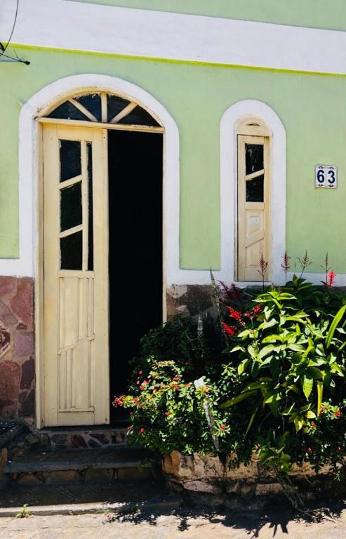 una porta aperta di una casa con fiori davanti di Casa63 a Lençóis